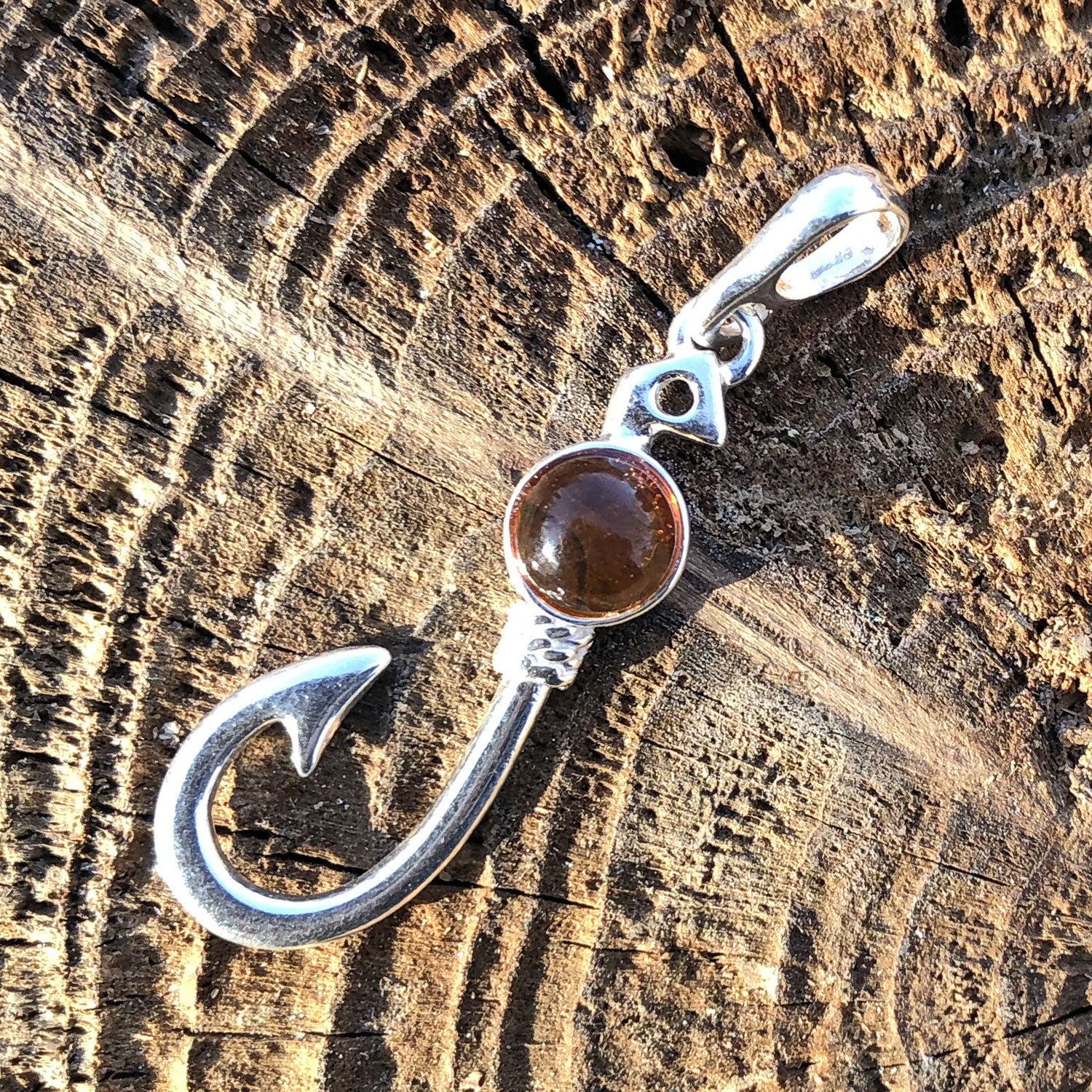 Kleiner Silberanhänger in Form eines Angelhakens mit Bernstein