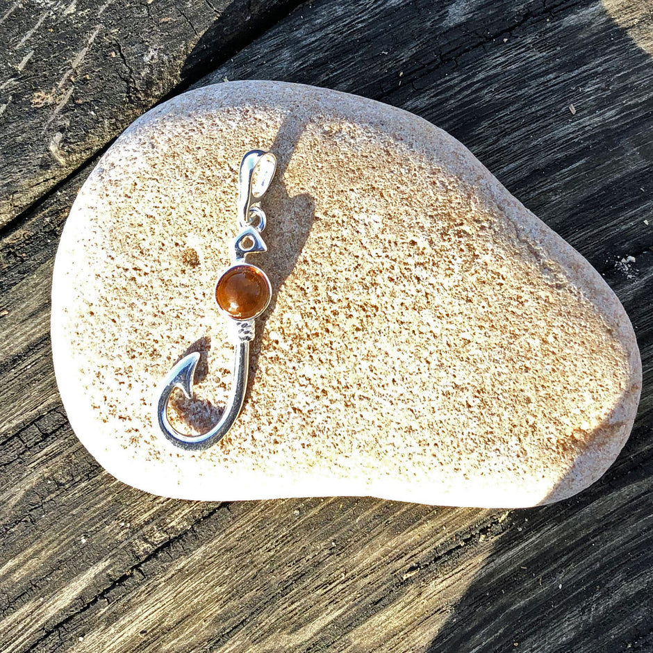 Kleiner Silberanhänger in Form eines Angelhakens mit Bernstein