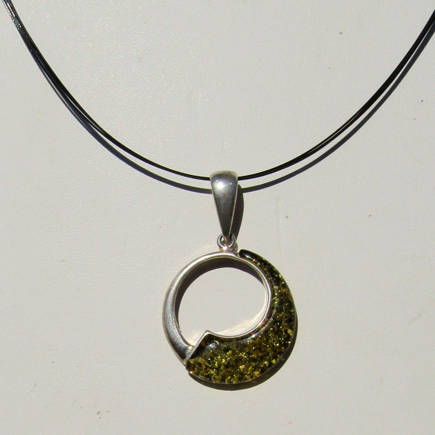 Runder Anhänger aus grünlichem Bernstein und Silber