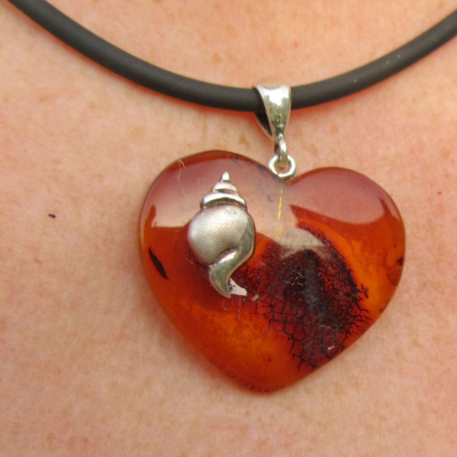 Kognacfarbenes Bernsteinherz mit silberner Schnecke