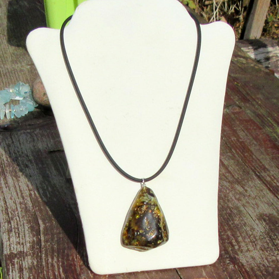 Dunkles Bernsteinstück mit Einschlüssen und Silberöse