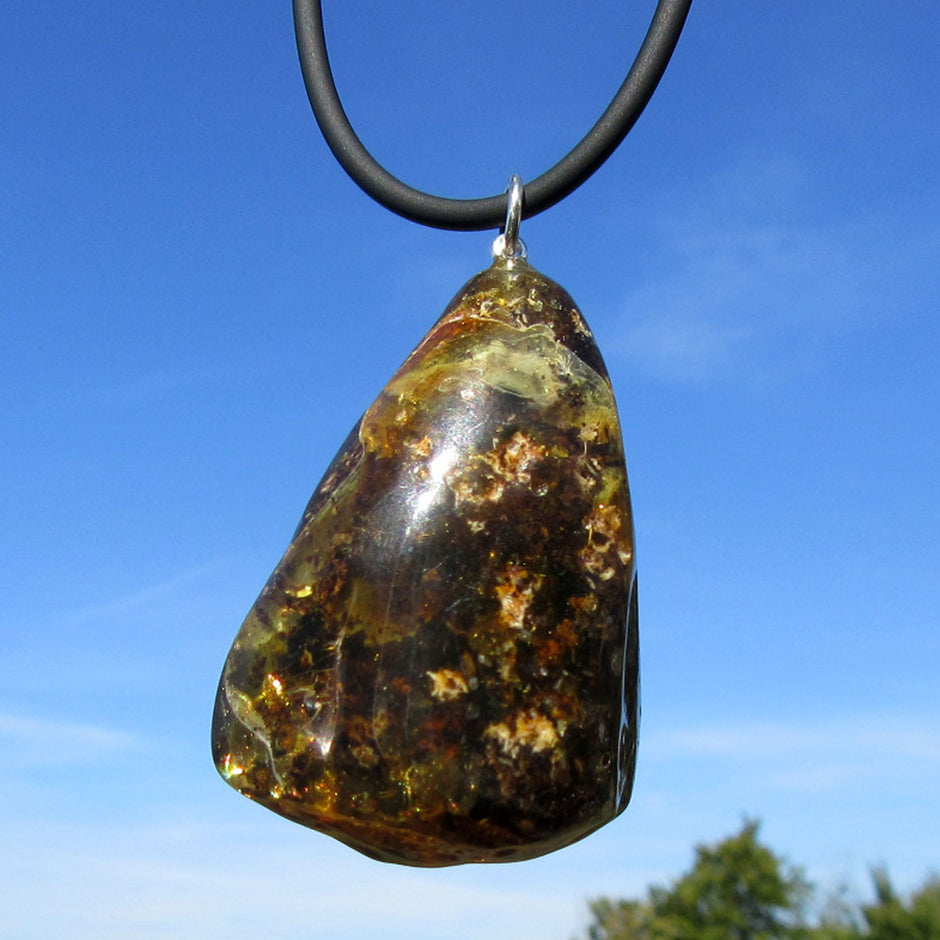 Dunkles Bernsteinstück mit Einschlüssen und Silberöse