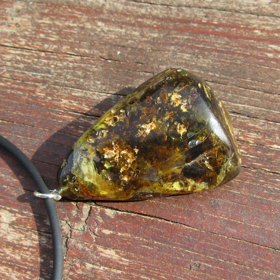 Dunkles Bernsteinstück mit Einschlüssen und Silberöse