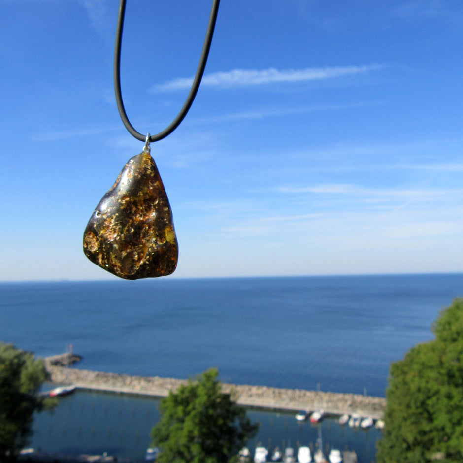 Dunkles Bernsteinstück mit Einschlüssen und Silberöse