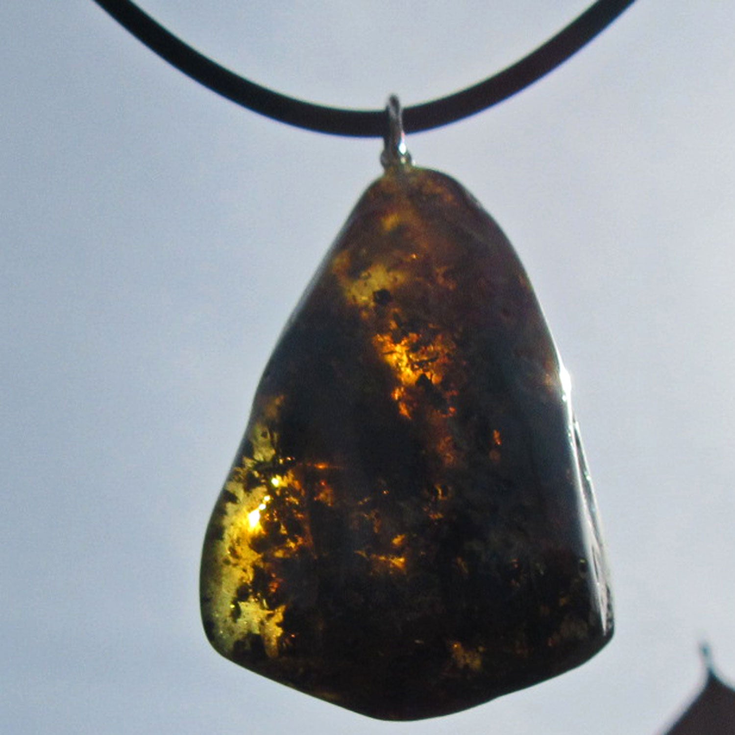 Dunkles Bernsteinstück mit Einschlüssen und Silberöse