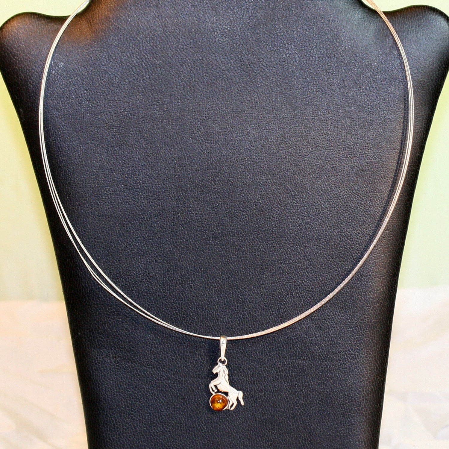 Anhänger als Pferd aus Silber mit Bernsteinperle