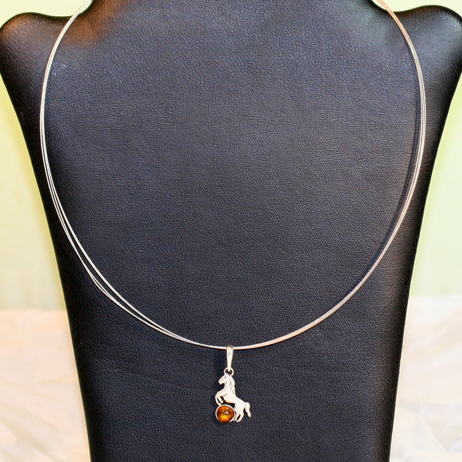 Anhänger als Pferd aus Silber mit Bernsteinperle