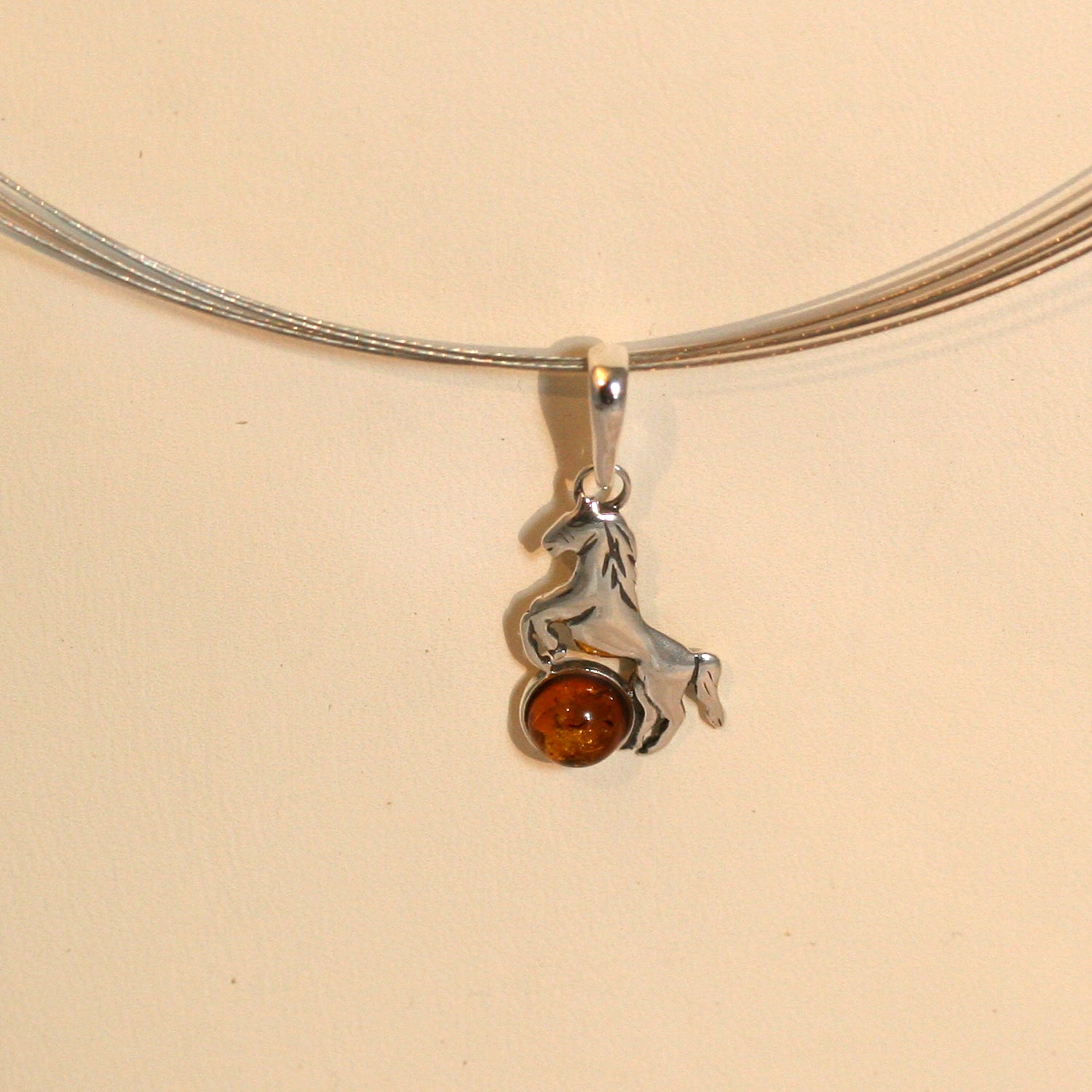 Anhänger als Pferd aus Silber mit Bernsteinperle