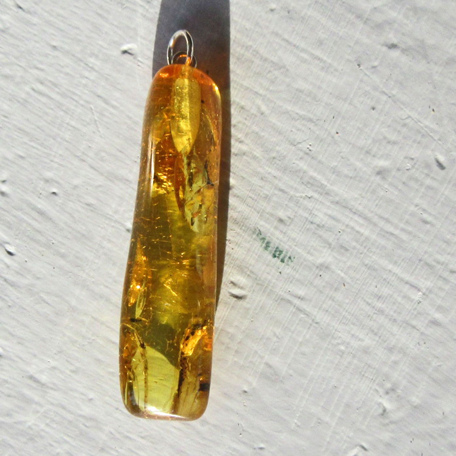 Länglicher Bernstein-Anhänger mit Inklusen von Rügen