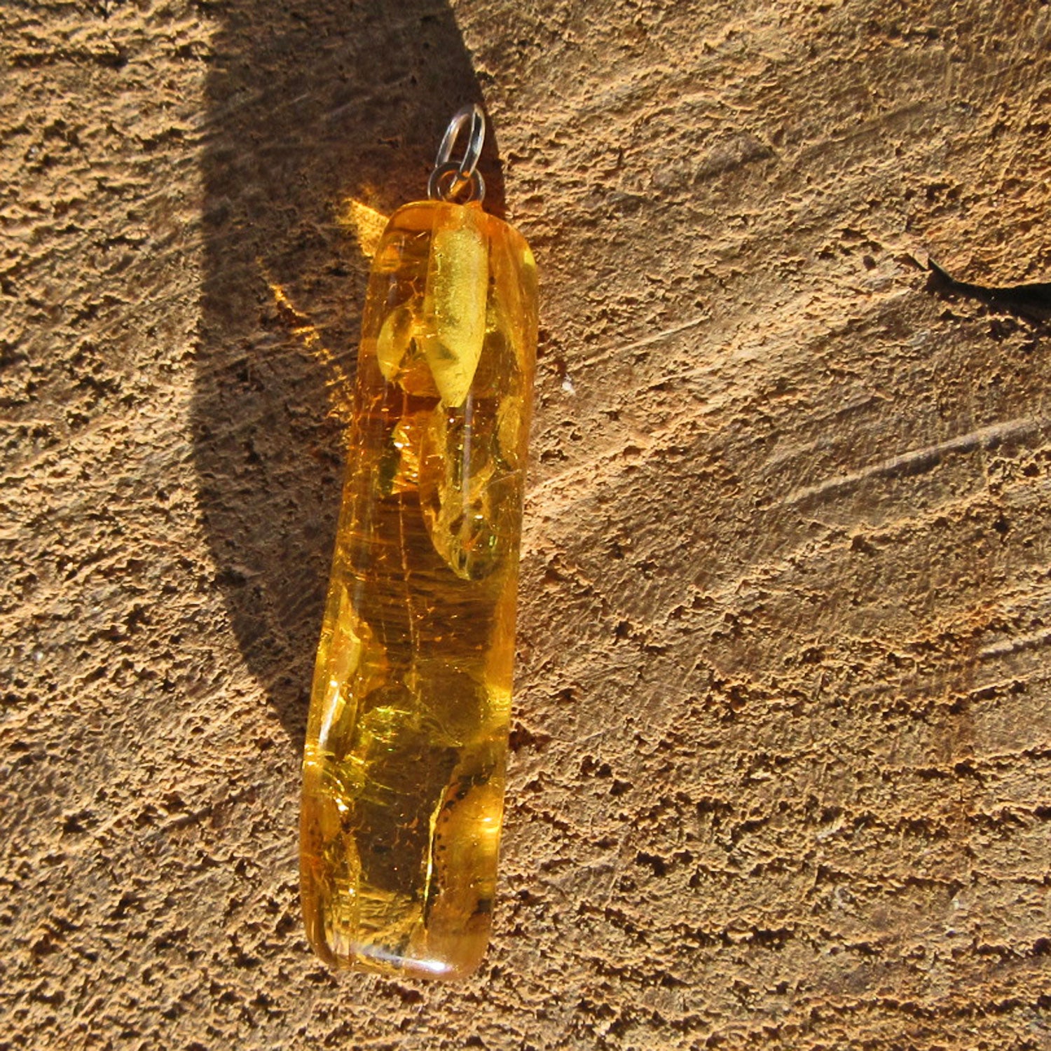 Länglicher Bernstein-Anhänger mit Inklusen von Rügen