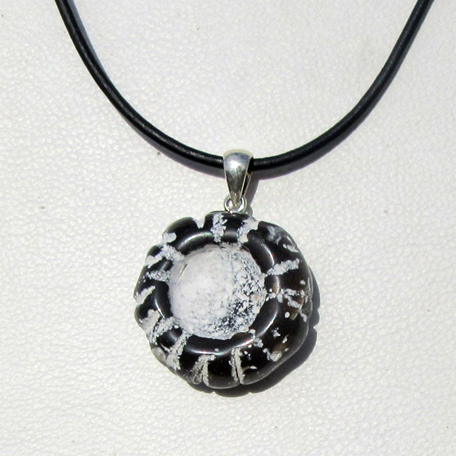 Polierter Steinkern eines Kronenseeigels an Silberöse