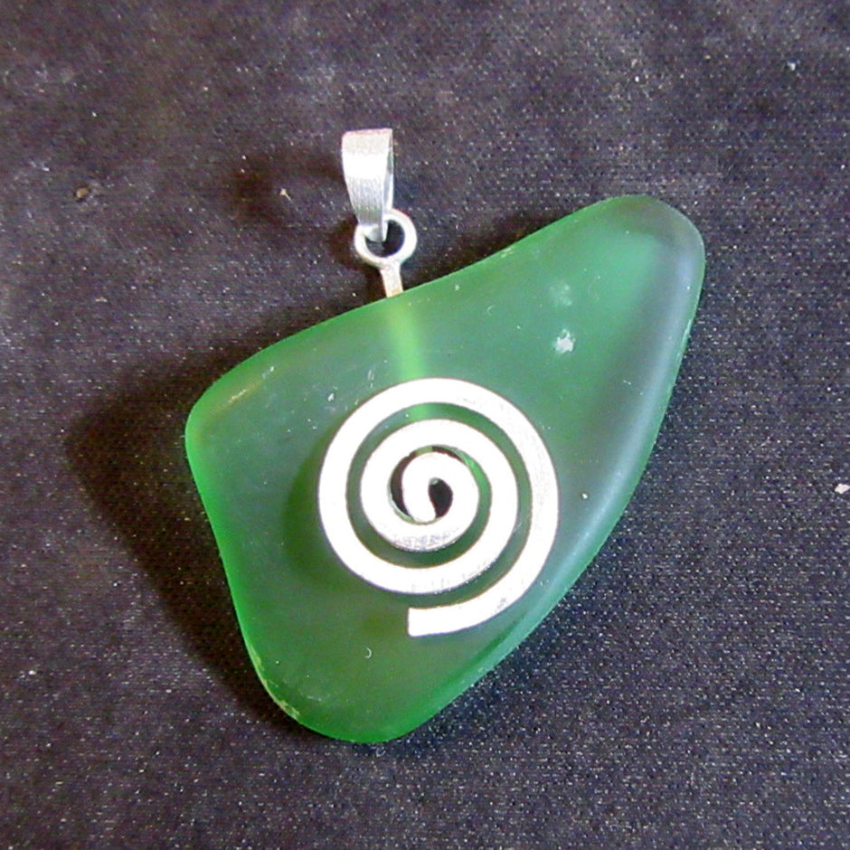 Anhänger aus einem grünem Seeglasstück auf einer gebürsteten Silberspirale