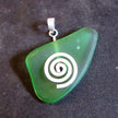 Anhänger aus einem grünem Seeglasstück auf einer gebürsteten Silberspirale