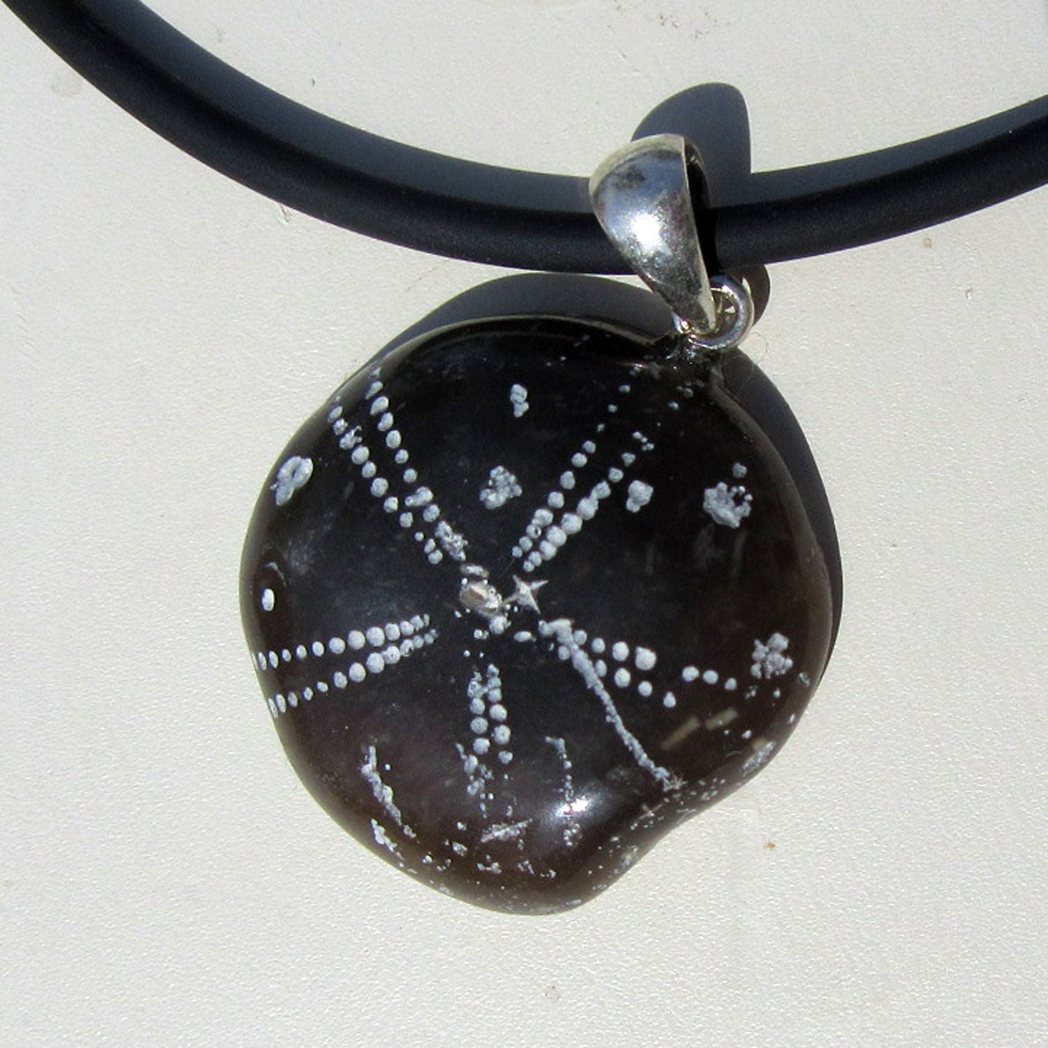 Flacher Anhänger aus versteinertem Seeigel, poliert