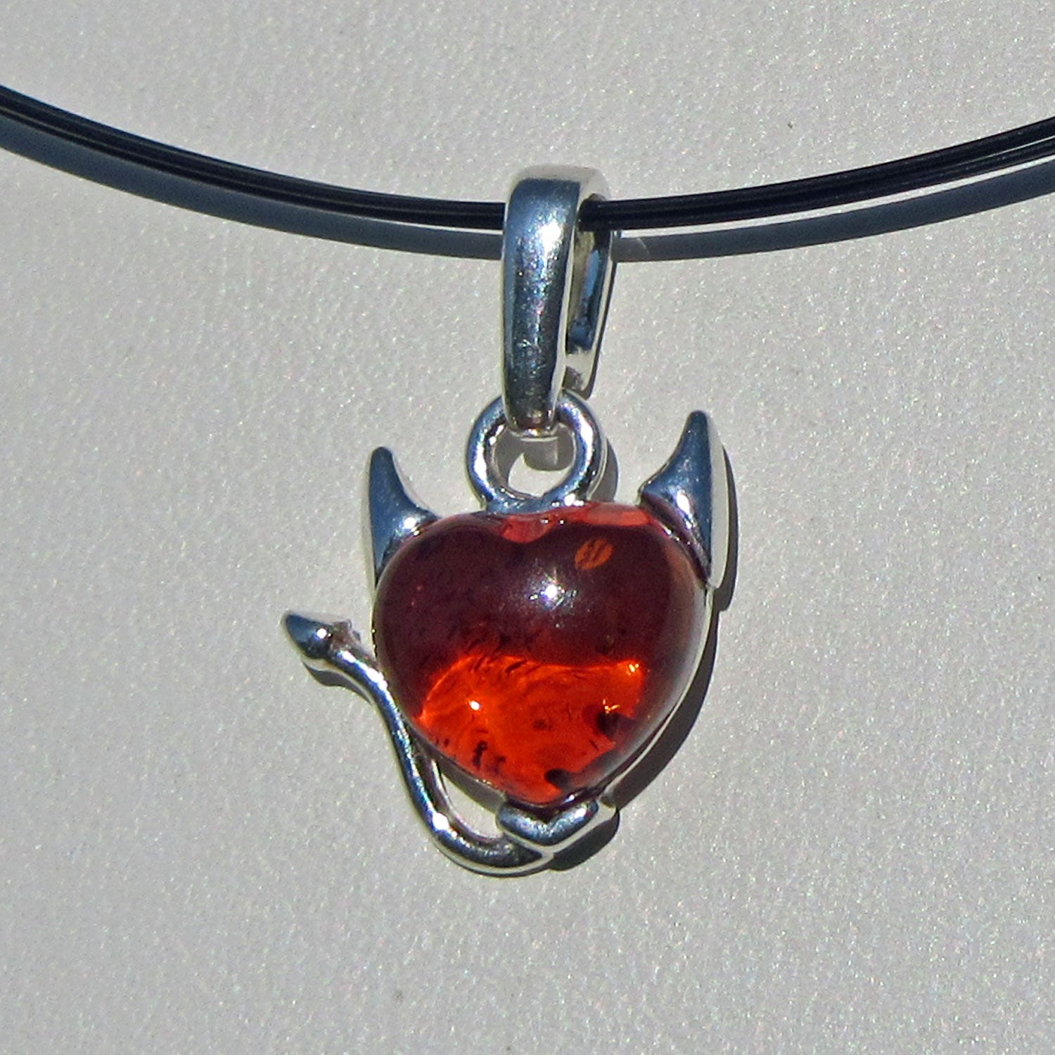 Silberanhänger mit kognacfarbenem Bernsteinherz und Teufel