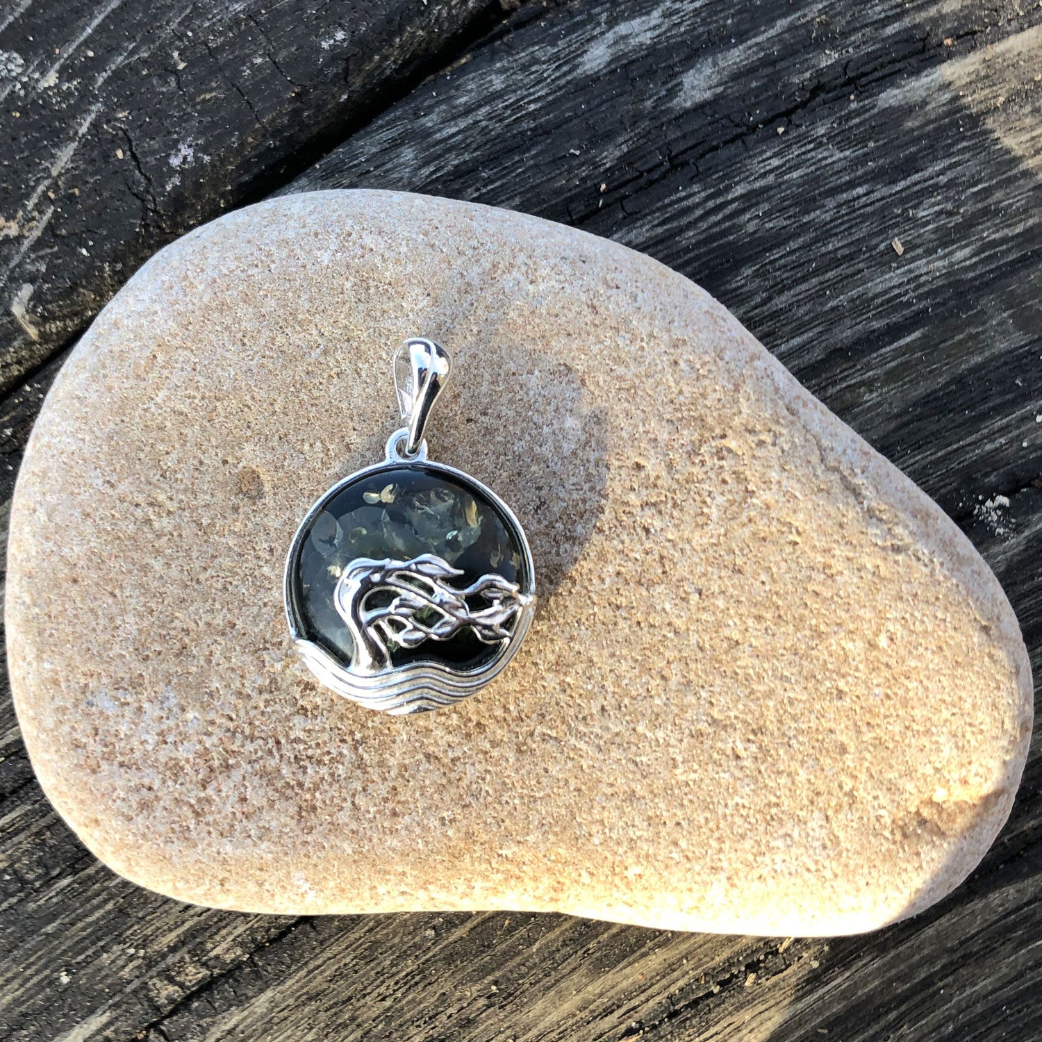 Runder Anhänger aus Bernstein mit Silber-Windflüchtern