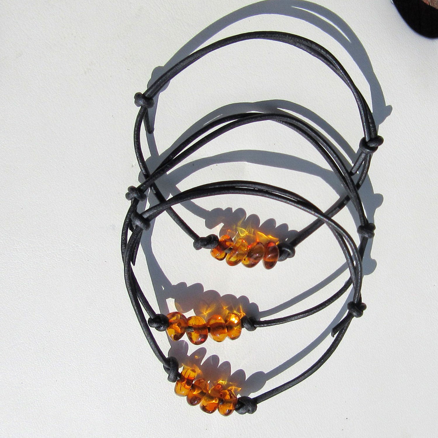 Schwarzes Lederarmband mit vier kleinen kognacfarbenen Bernsteinen