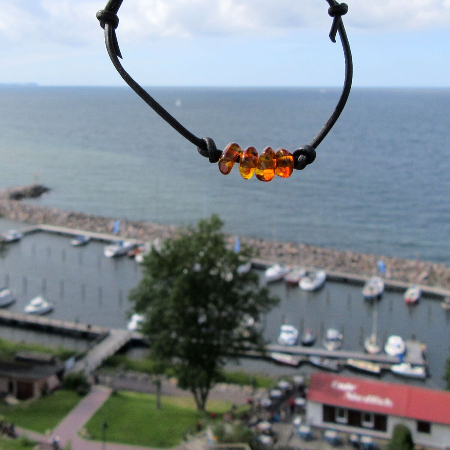 Schwarzes Lederarmband mit vier kleinen kognacfarbenen Bernsteinen