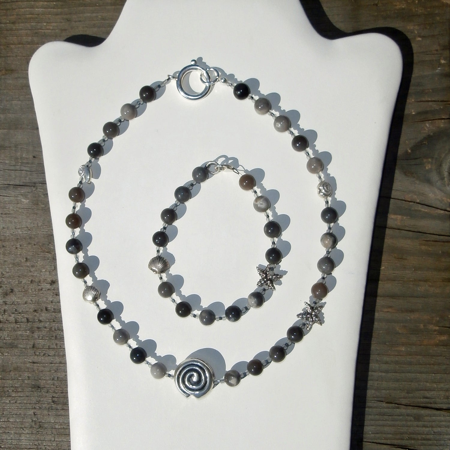 Collier aus fein polierten, verschiedenfarbigen Feuersteinperlen mit maritimen Silbermotiven