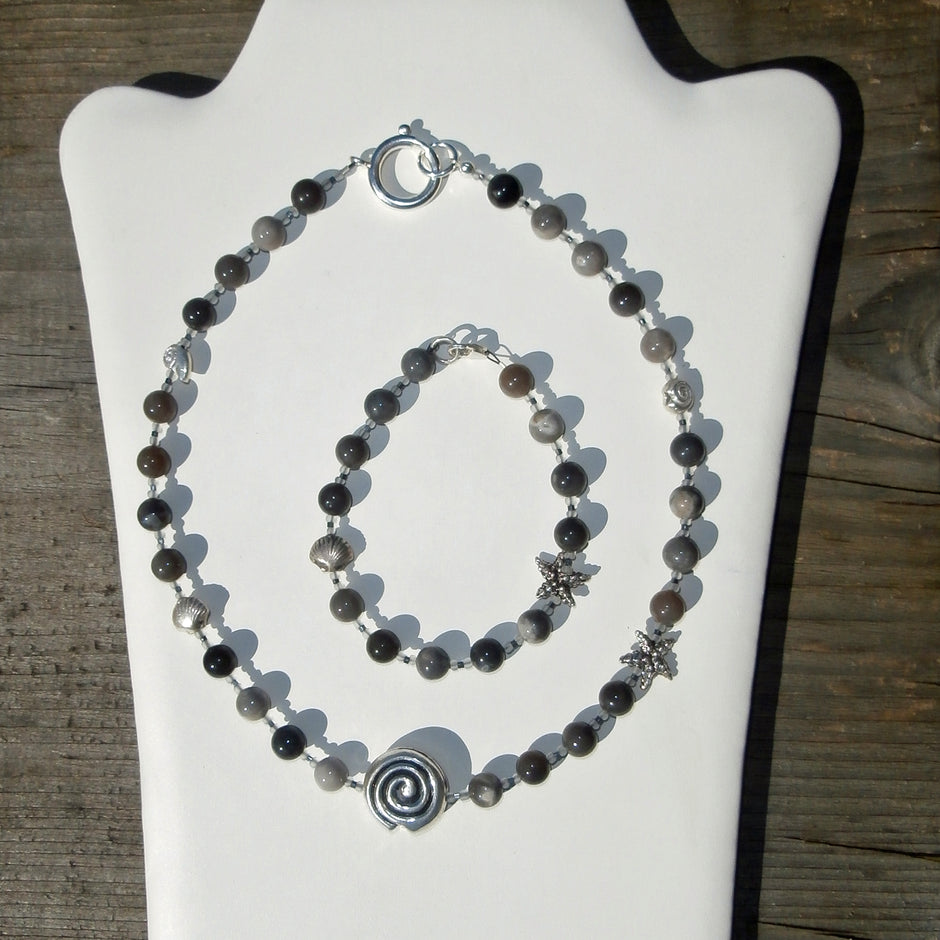 Collier aus fein polierten, verschiedenfarbigen Feuersteinperlen mit maritimen Silbermotiven