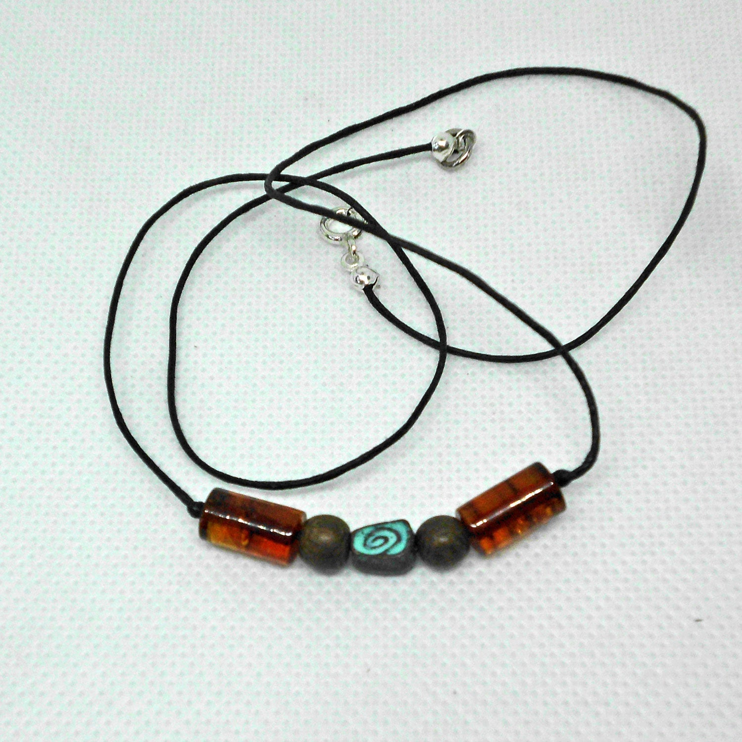 Grüne Schnecke aus Kupfer mit Bernstein am Baumwollcollier