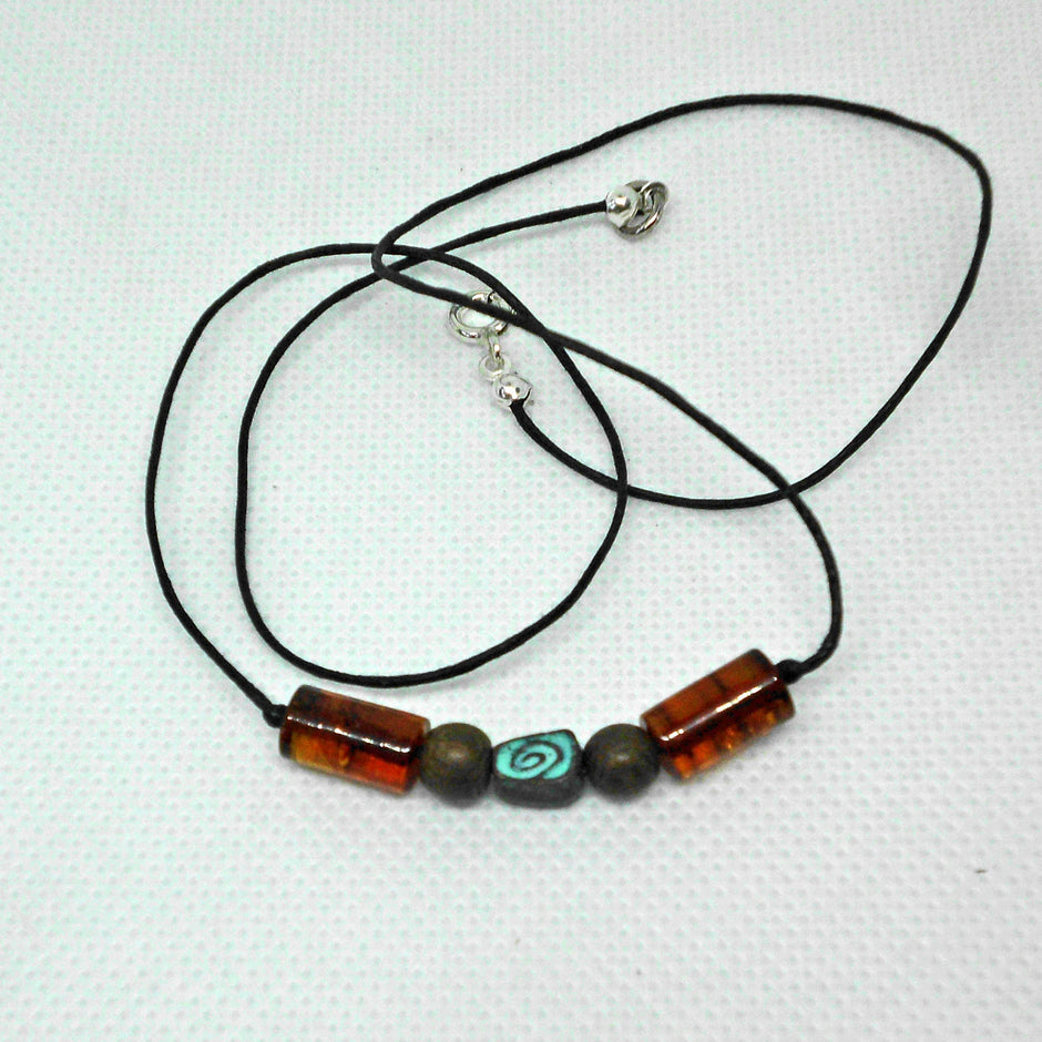 Grüne Schnecke aus Kupfer mit Bernstein am Baumwollcollier