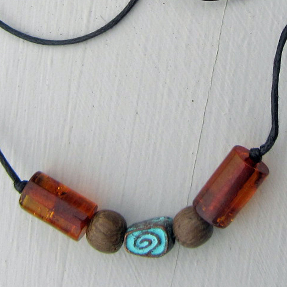 Grüne Schnecke aus Kupfer mit Bernstein am Baumwollcollier