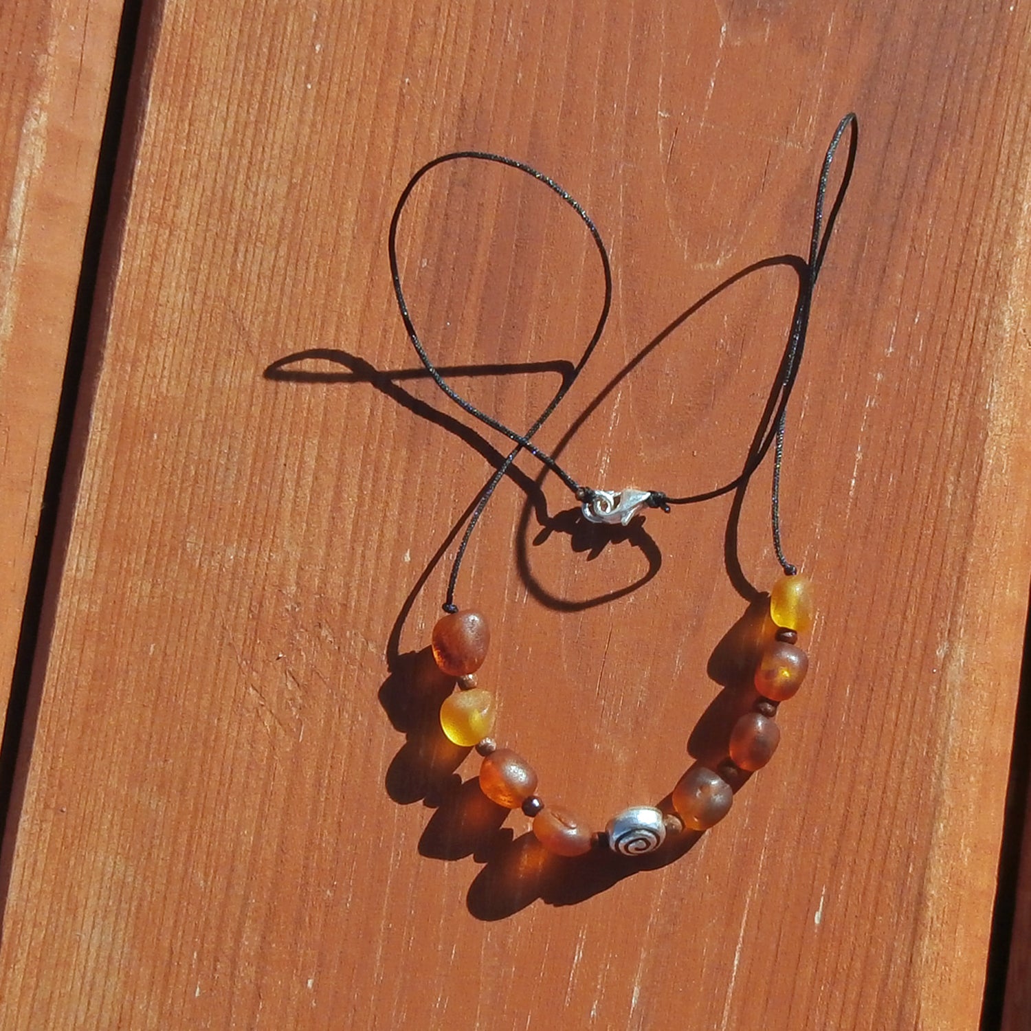 Collier aus unpolierten Bernsteinen und silberner Schnecke