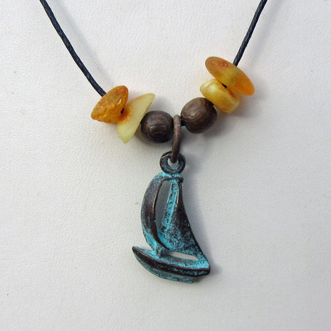Bernsteine und patiniertes Segelboot am Baumwollcollier