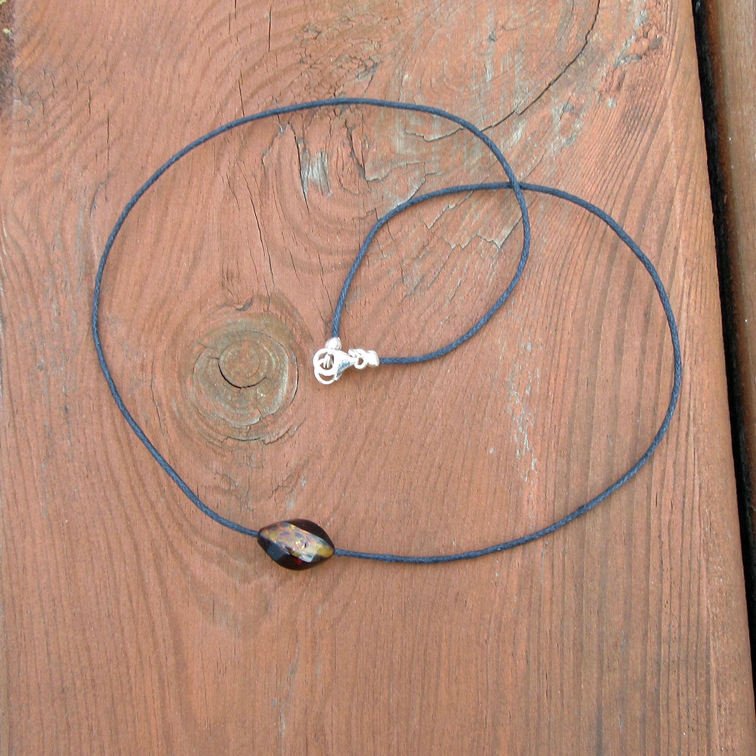 Einzelstück: Gedrehte Bernsteinperle auf Baumwollcollier
