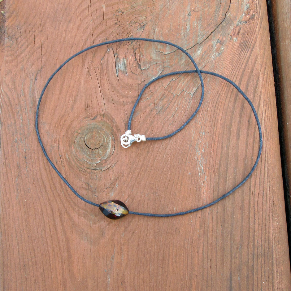 Einzelstück: Gedrehte Bernsteinperle auf Baumwollcollier