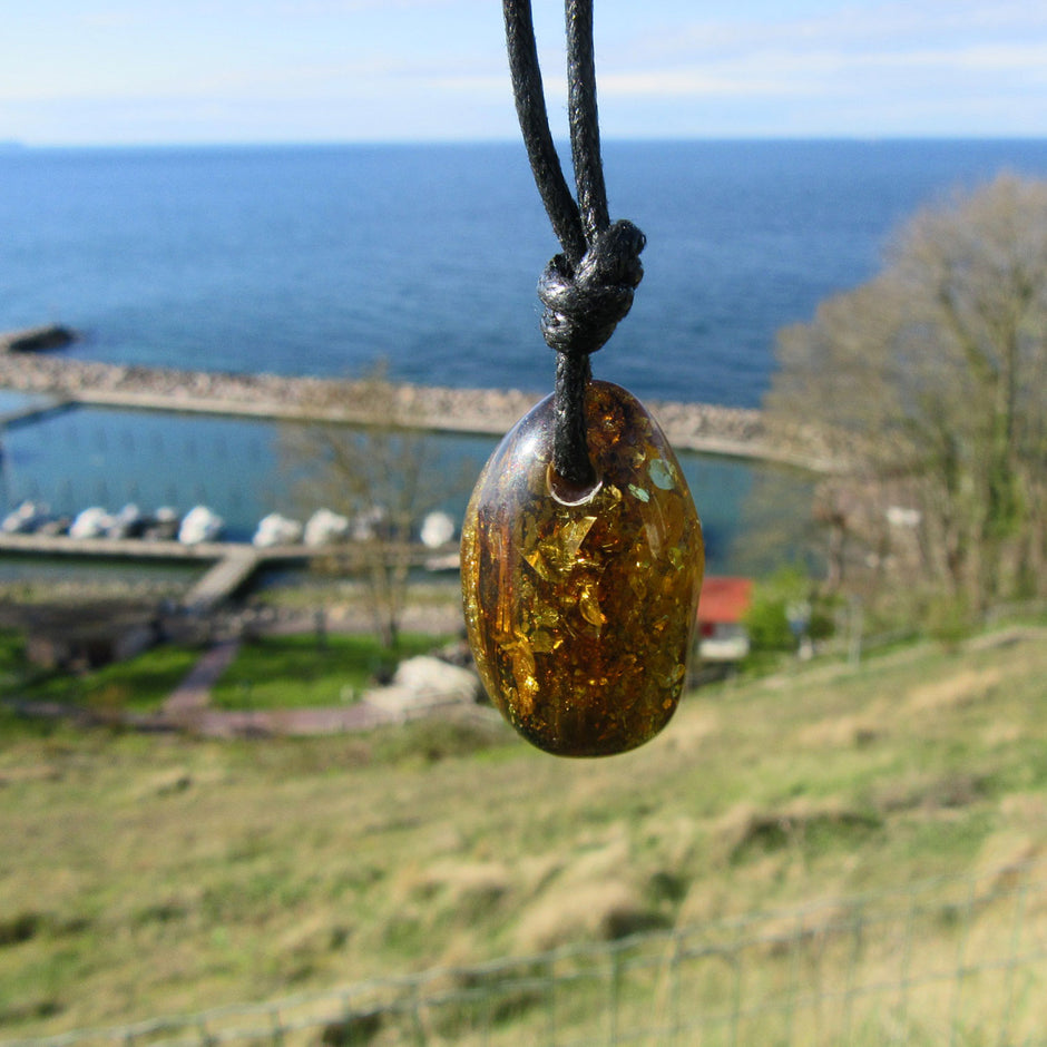 Dunkles, grünliches Bernsteinstück mit Einschlüssen