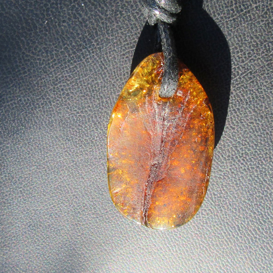 Dunkles, grünliches Bernsteinstück mit Einschlüssen