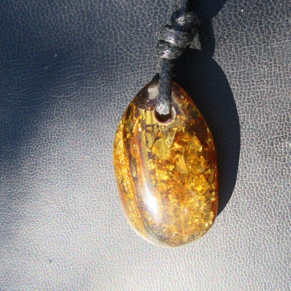 Dunkles, grünliches Bernsteinstück mit Einschlüssen