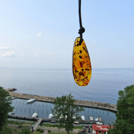 Einzigartiges Bernsteinstück mit Einschlüssen am Baumwollband