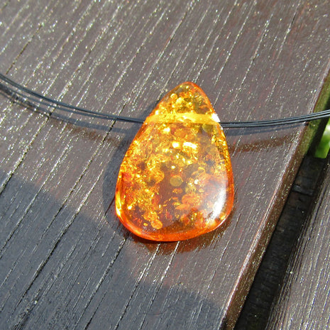 Tropfenförmiges Bernsteinstück mit Querbohrung