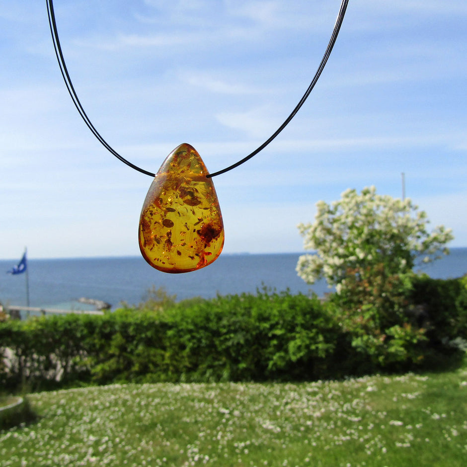 Tropfenförmiges Bernsteinstück mit Querbohrung