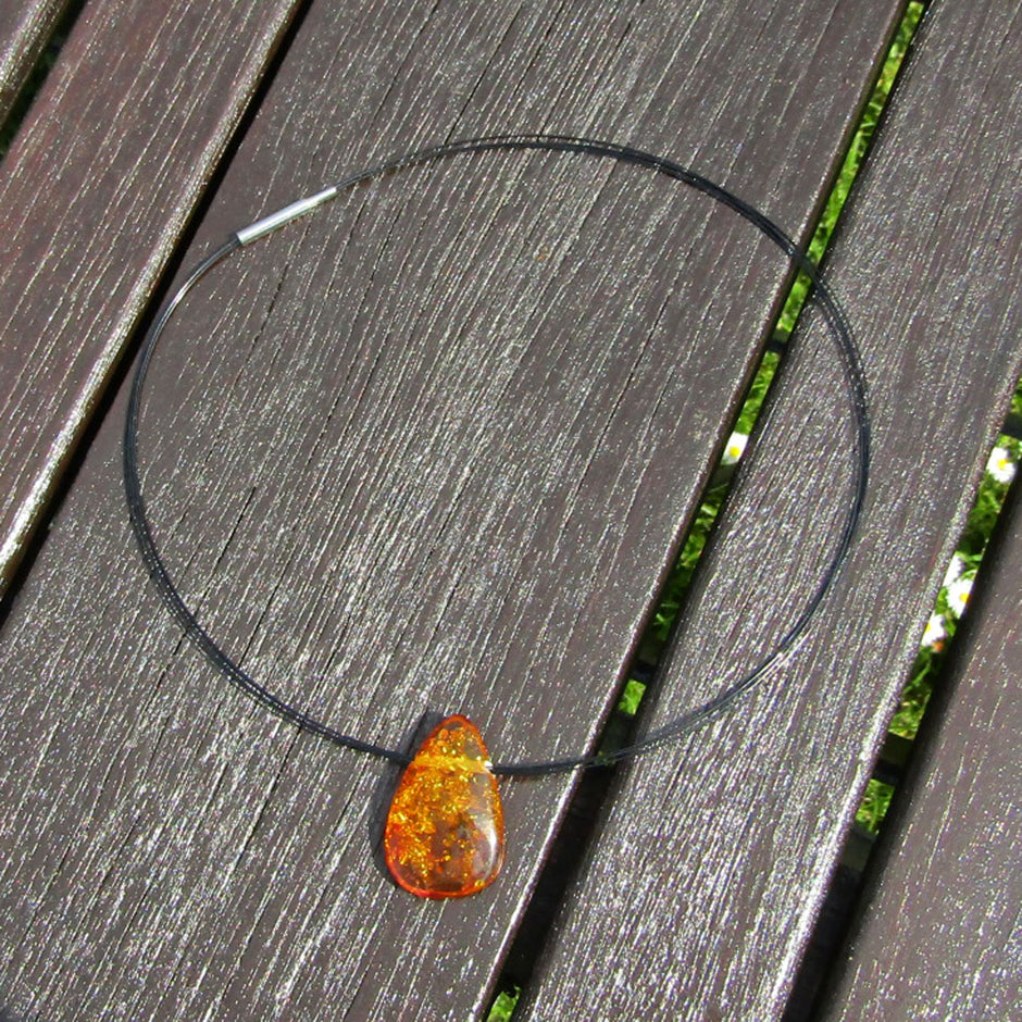 Tropfenförmiges Bernsteinstück mit Querbohrung