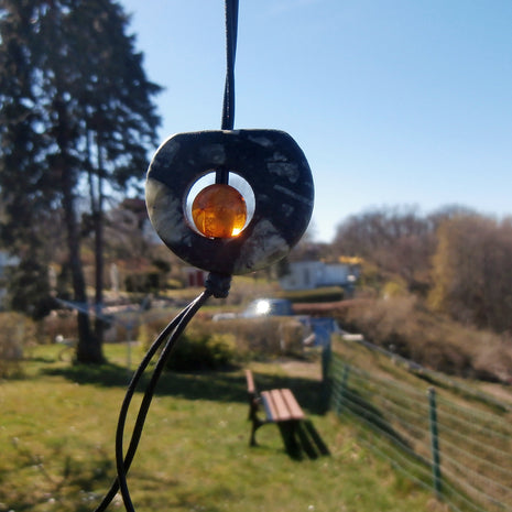 Kognacfarbene Bernsteinperle im Stein, langes Lederband