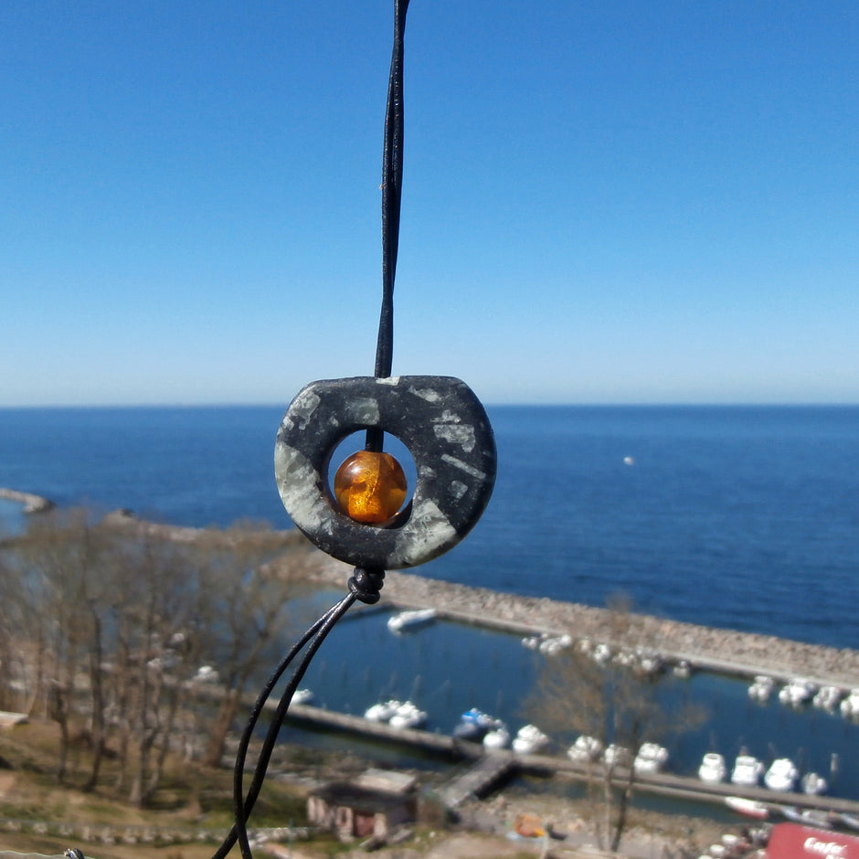 Kognacfarbene Bernsteinperle im Stein, langes Lederband