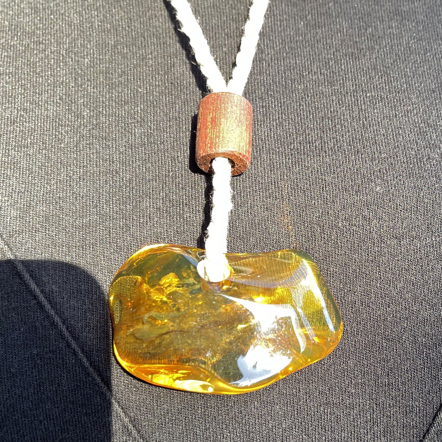 Einzigartiger Anhänger aus poliertem Bernstein mit Baumwollkordel