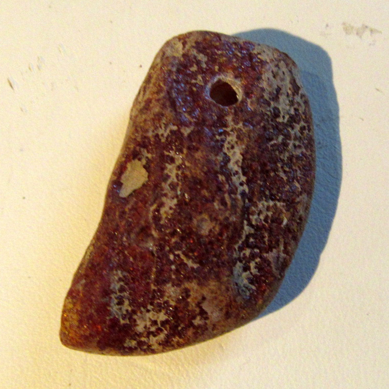 Dunkles Bernsteinstück, unpoliert und gebohrt