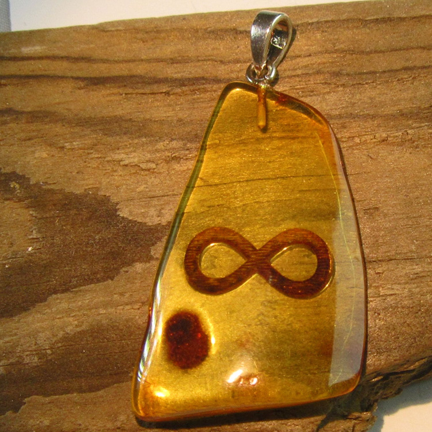 Polierter Bernsteinhänger mit Unendlichkeitssymbol