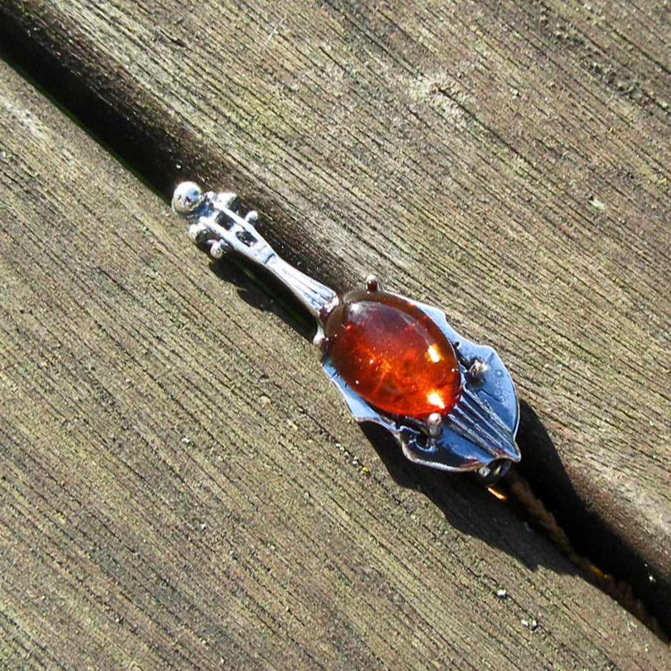 Brosche aus Silber und Bernstein in Cello-Form