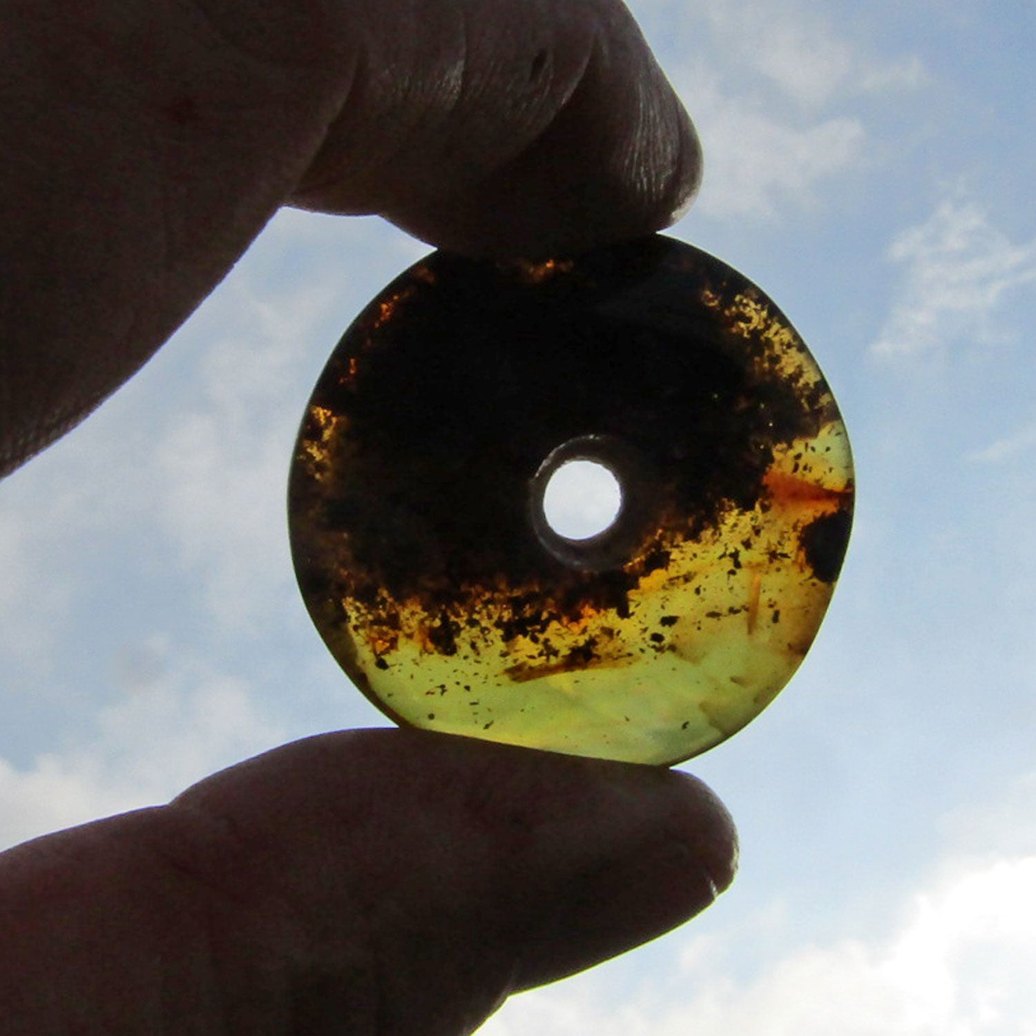 Großer, polierter Bernsteindonut mit Einschlüssen