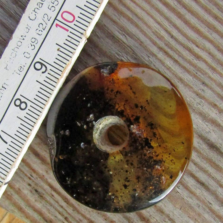 Großer, polierter Bernsteindonut mit Einschlüssen