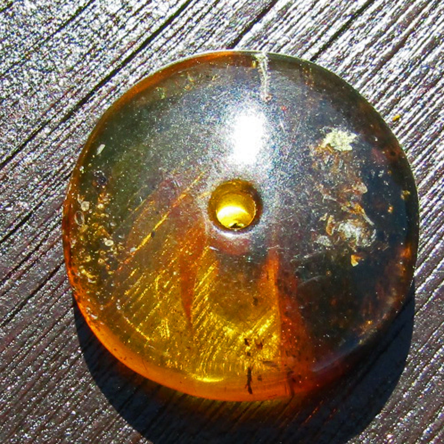 Bernsteindonut von Rügen mit dunklen Einschlüssen