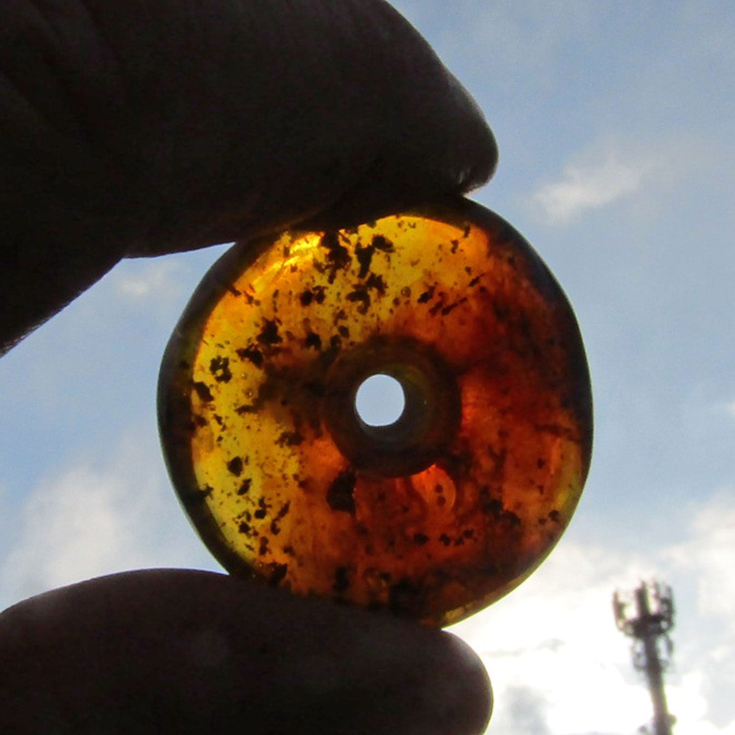 Schöner, kognacfarbener polierter Bernsteindonut, mit Einschlüssen