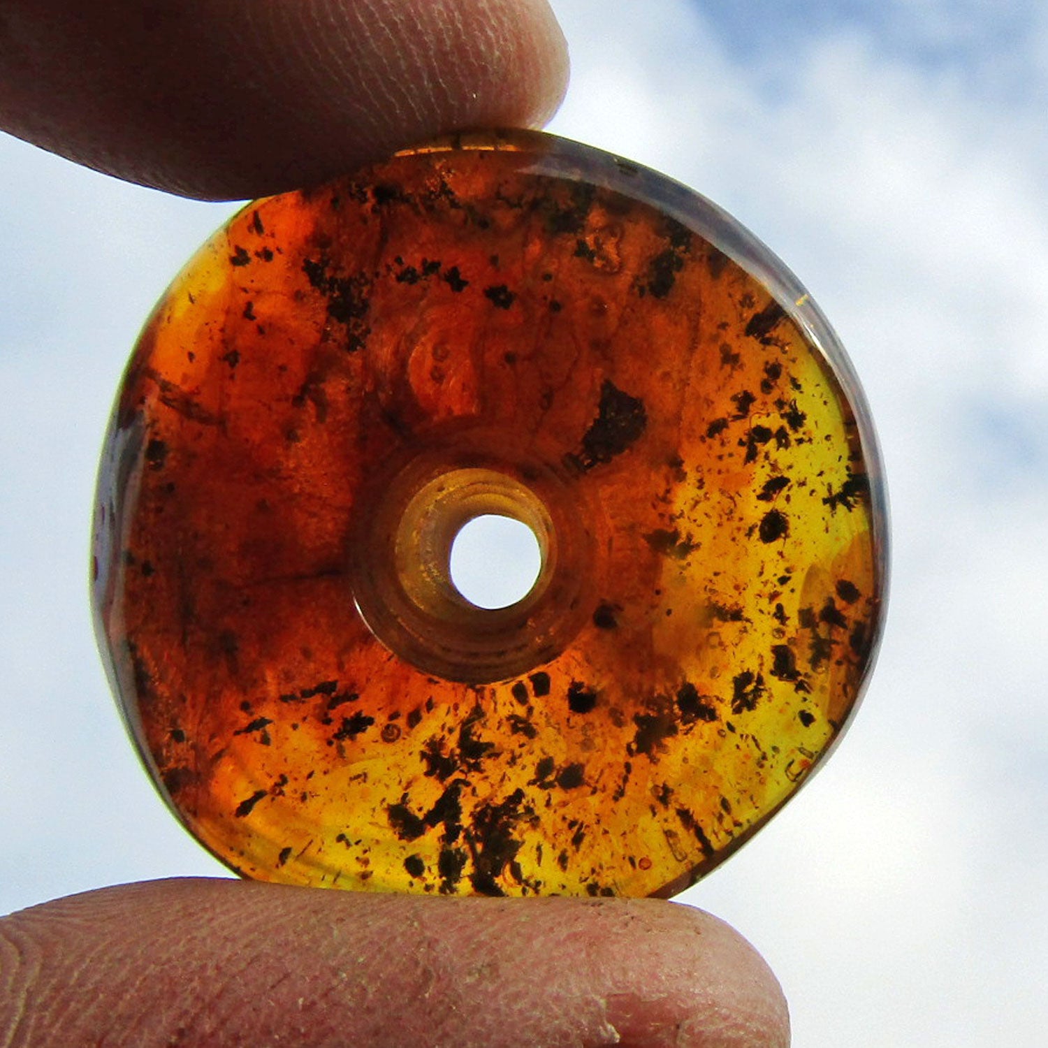 Schöner, kognacfarbener polierter Bernsteindonut, mit Einschlüssen