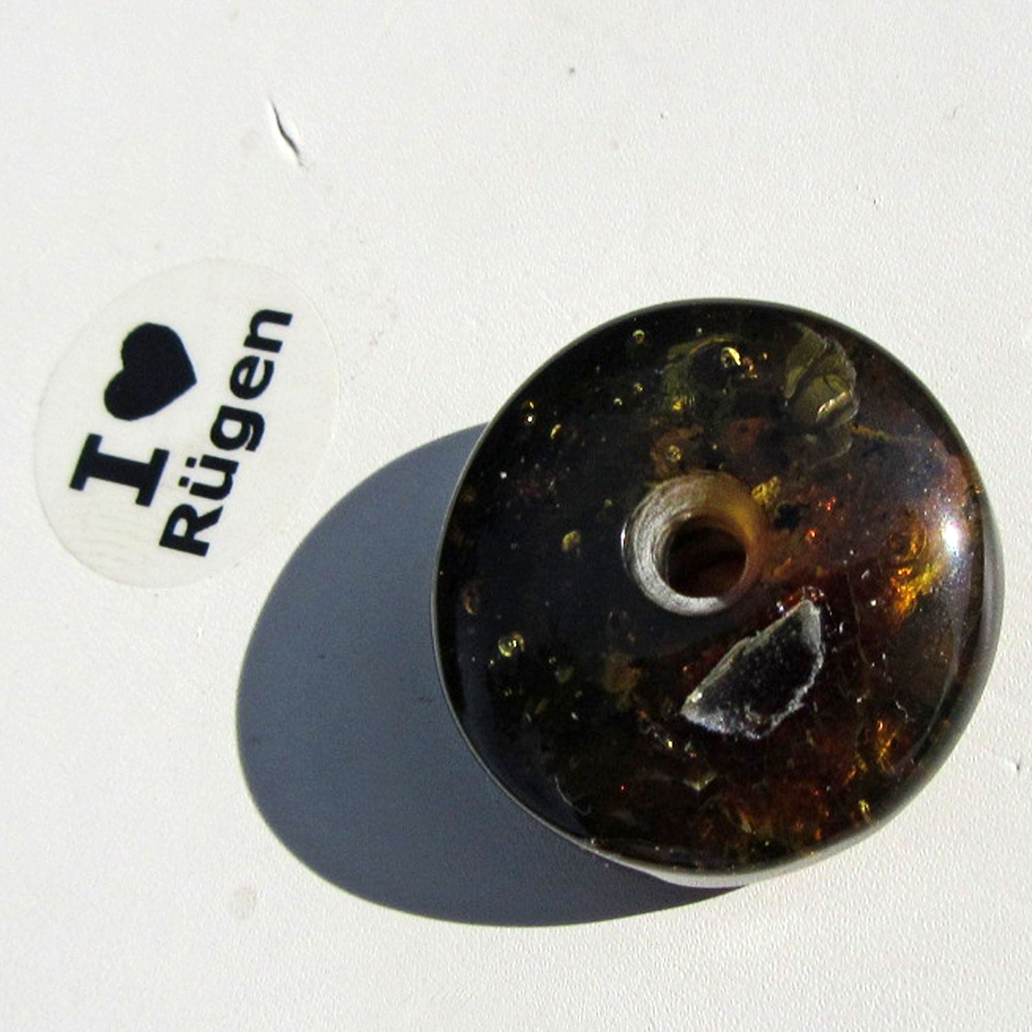 Dunkler Bernsteindonut mit Einschlüssen, rund geschliffen